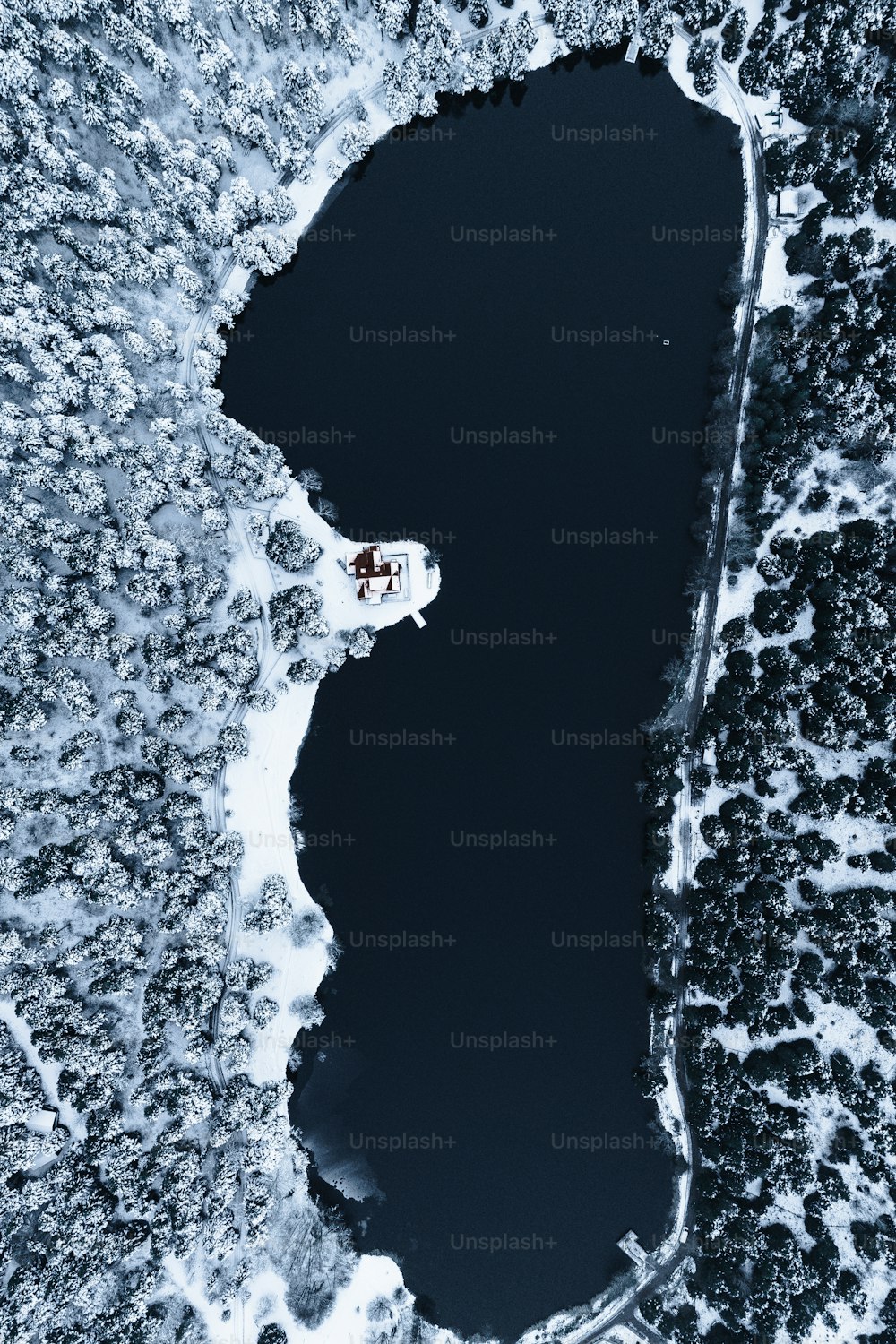 uma vista aérea de um lago cercado por neve
