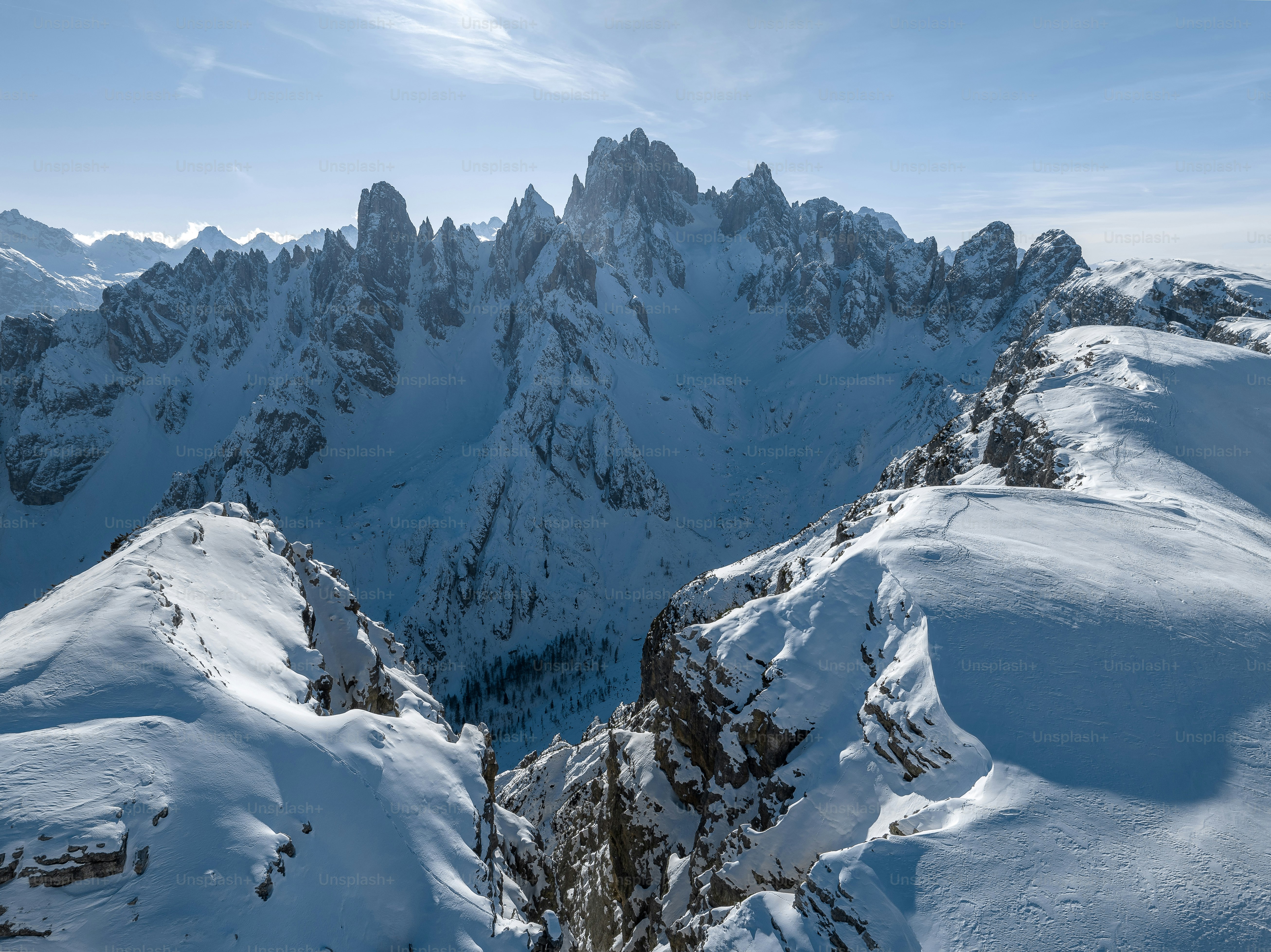 A mountain range covered in snow under a blue sky photo – Sky Image on ...