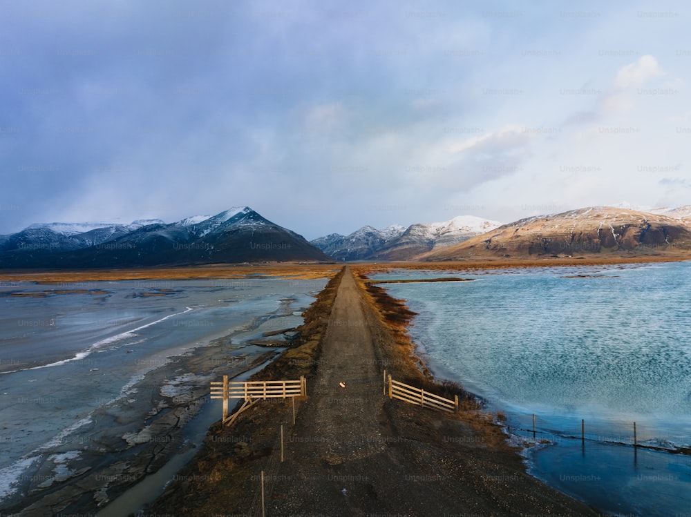 a dirt road next to a body of water