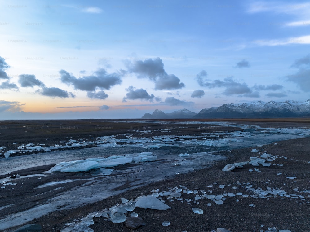 a body of water surrounded by ice and mountains