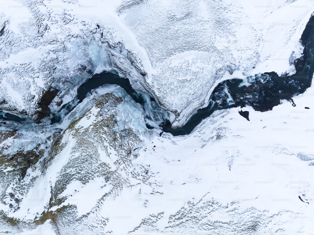 an aerial view of a river running through a snow covered mountain