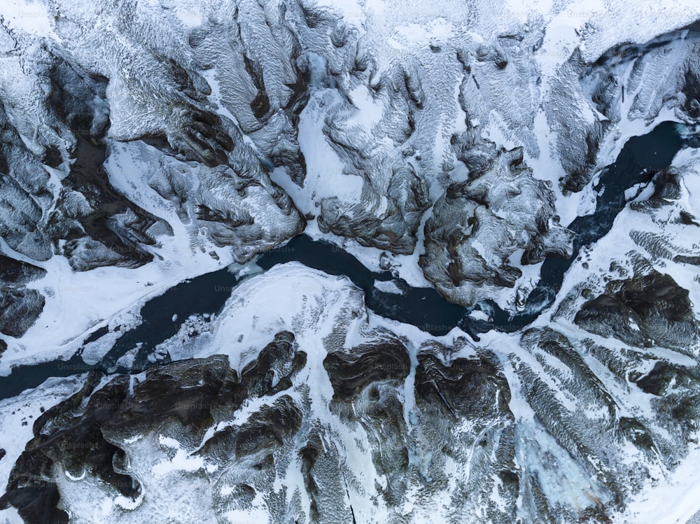Una vista aérea de montañas y ríos cubiertos de nieve