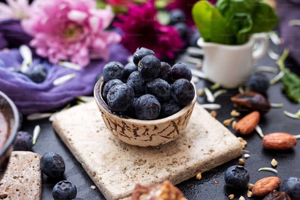 a bowl of blueberries and almonds on a table