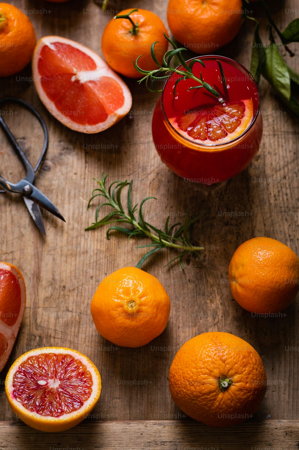 ein Holztisch mit Orangen und Grapefruits