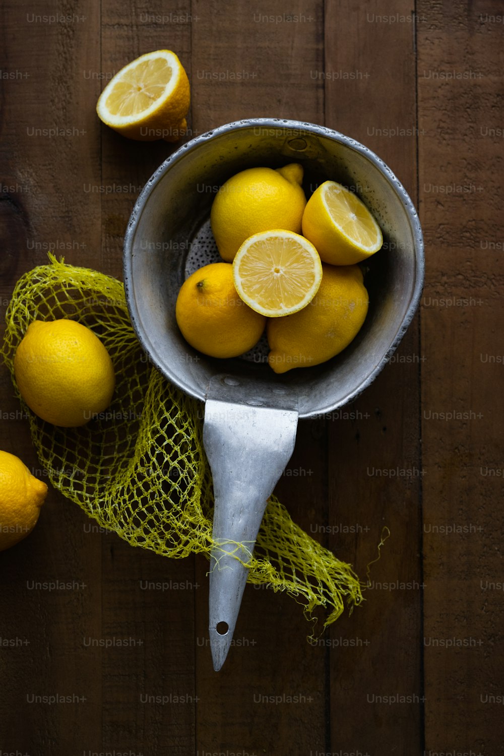 a bucket full of lemons on a wooden table