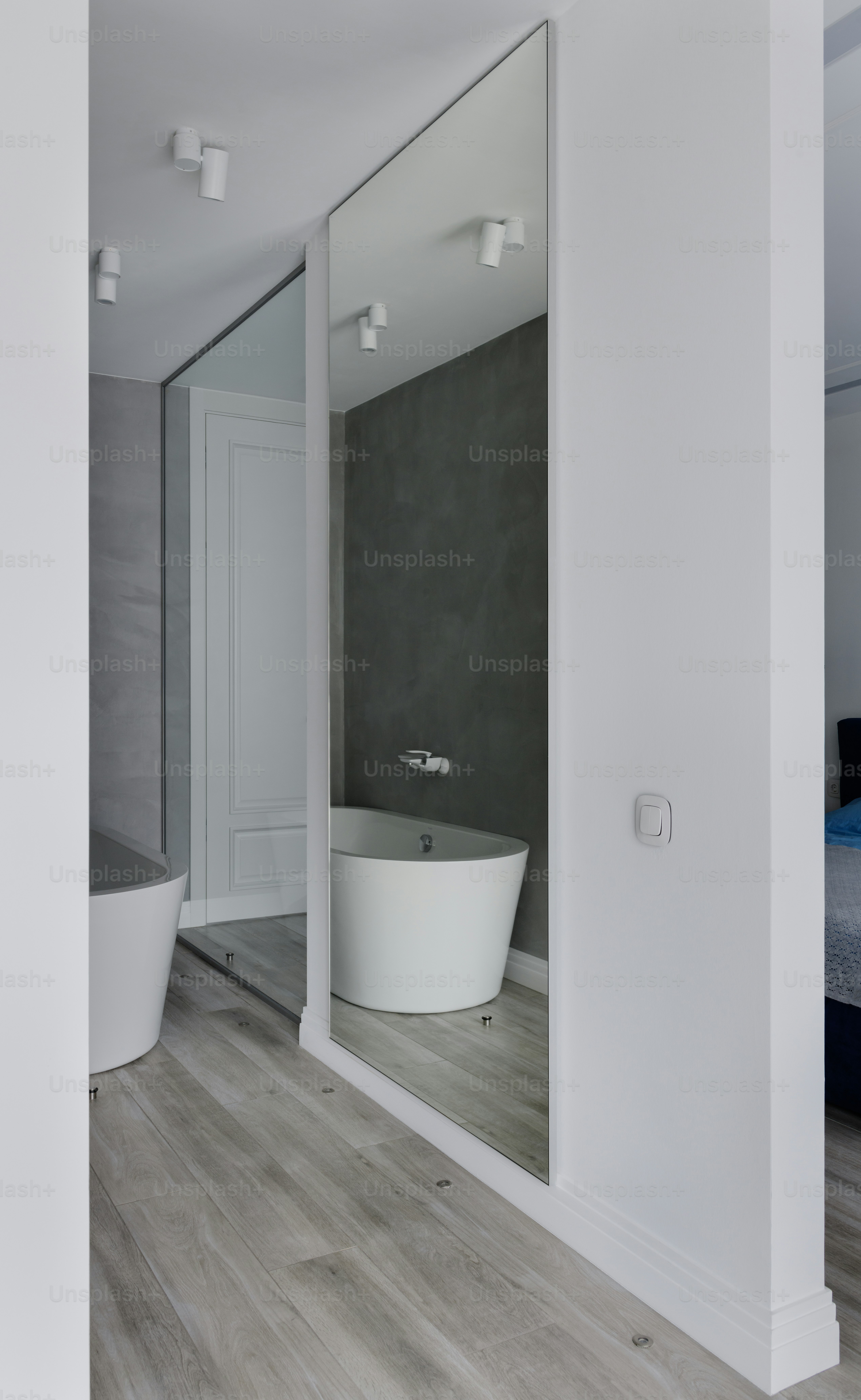 a white bath tub sitting next to a bathroom mirror