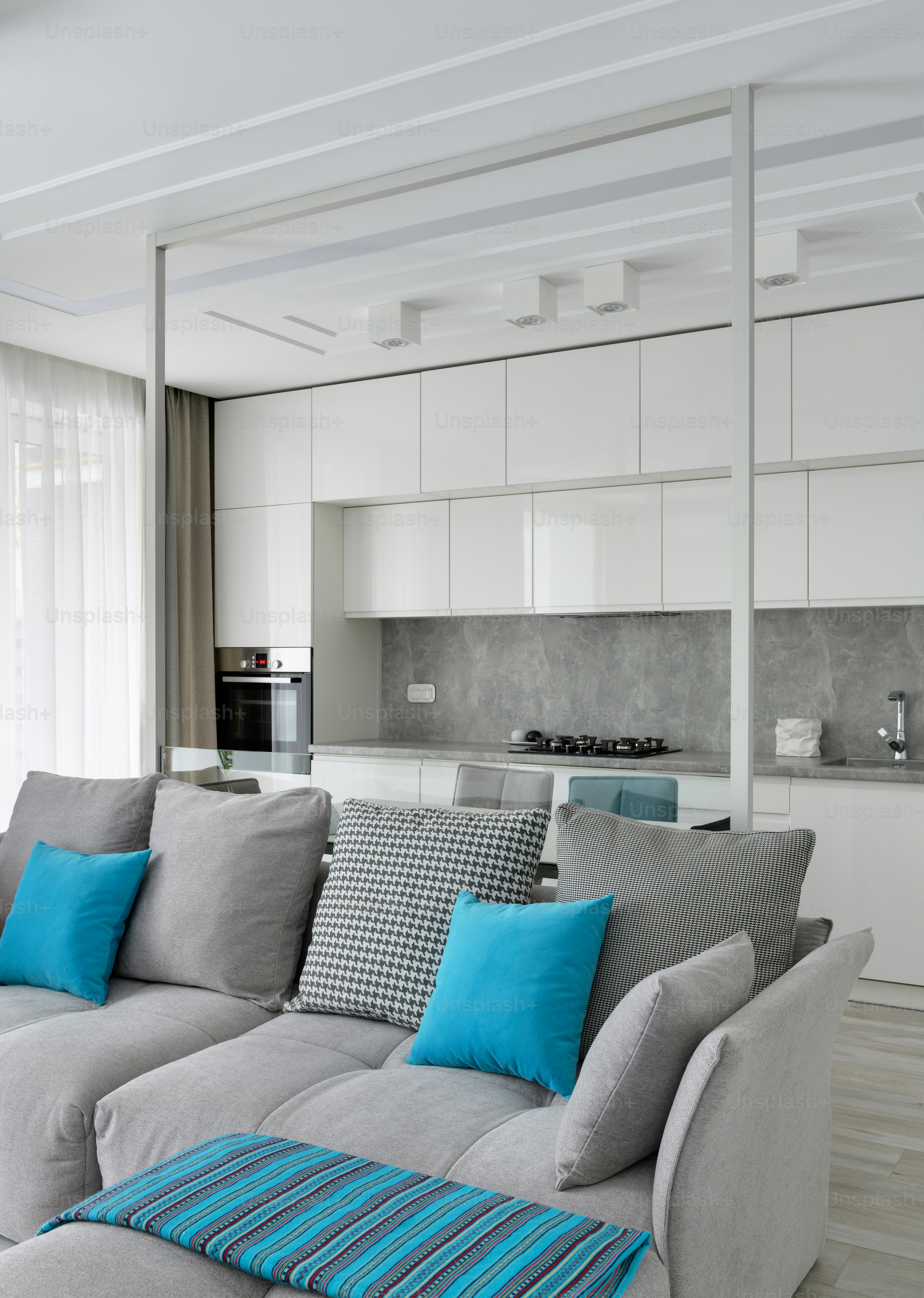 A living room with a gray couch and blue pillows photo – Couch Image on ...