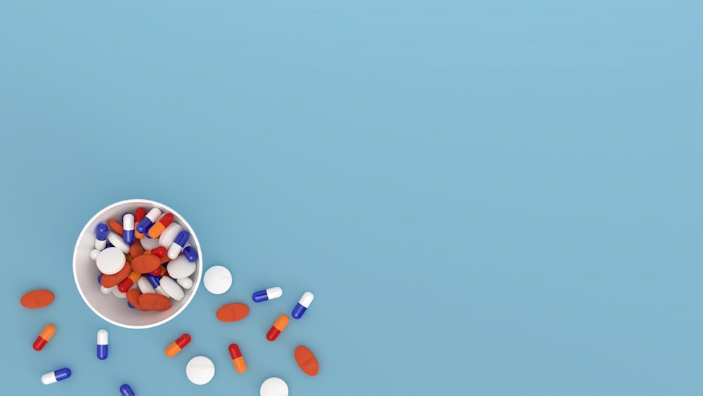 a white bowl filled with pills on top of a blue surface