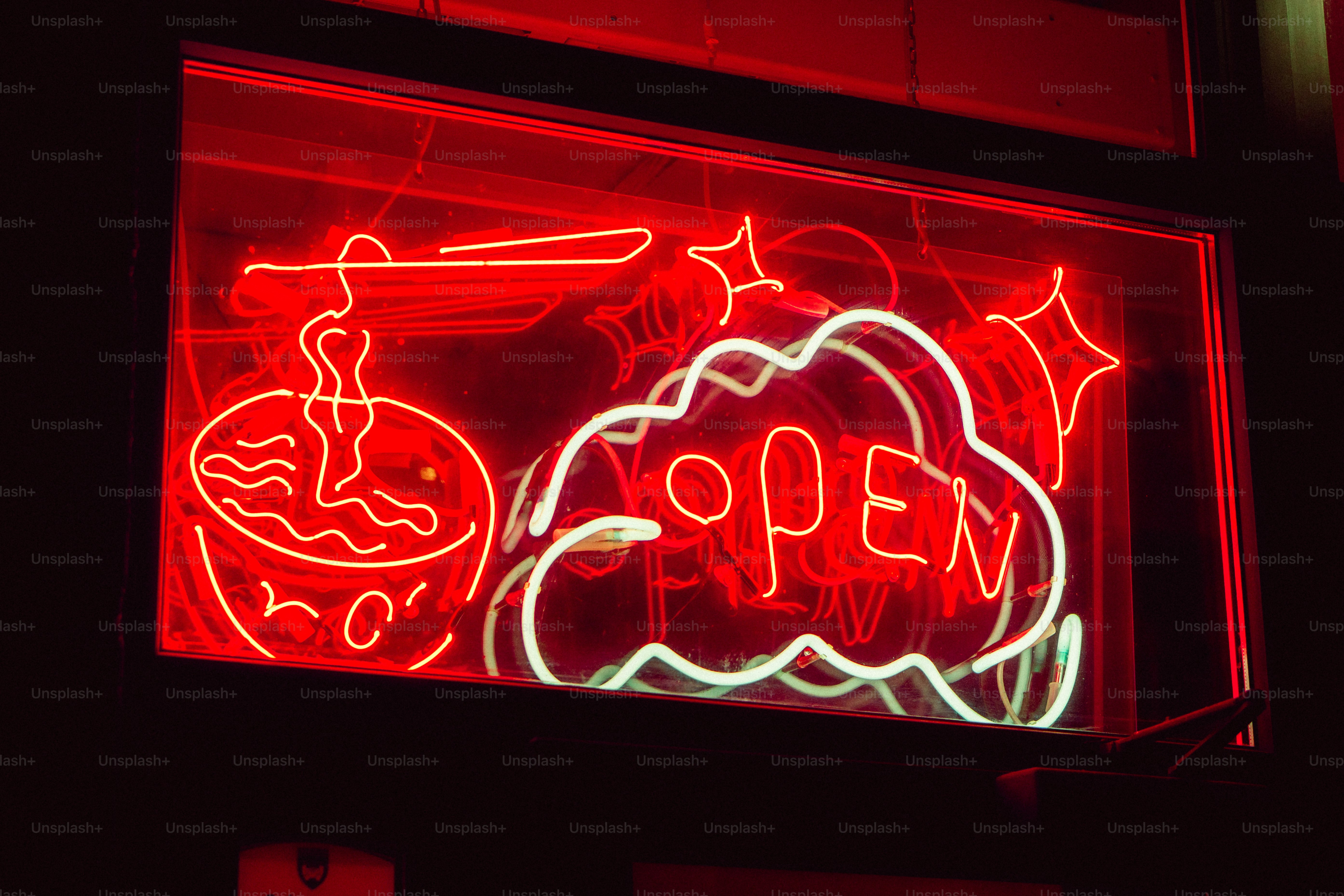 A neon sign that is on the side of a building photo – Neon light Image ...