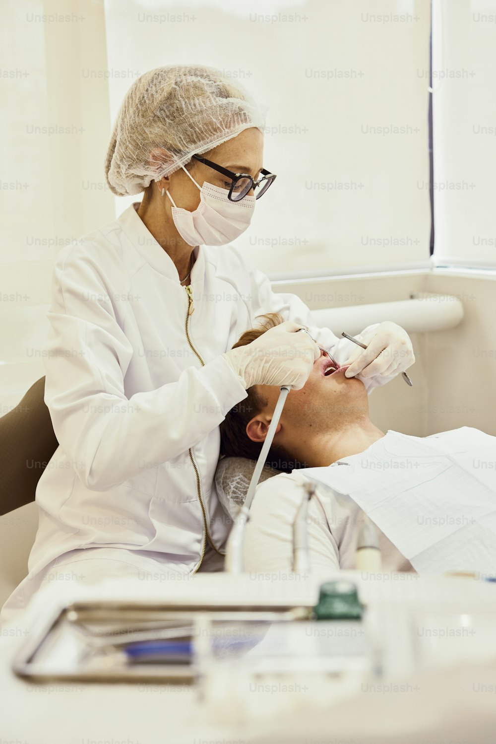 a man getting his teeth checked by a dentist