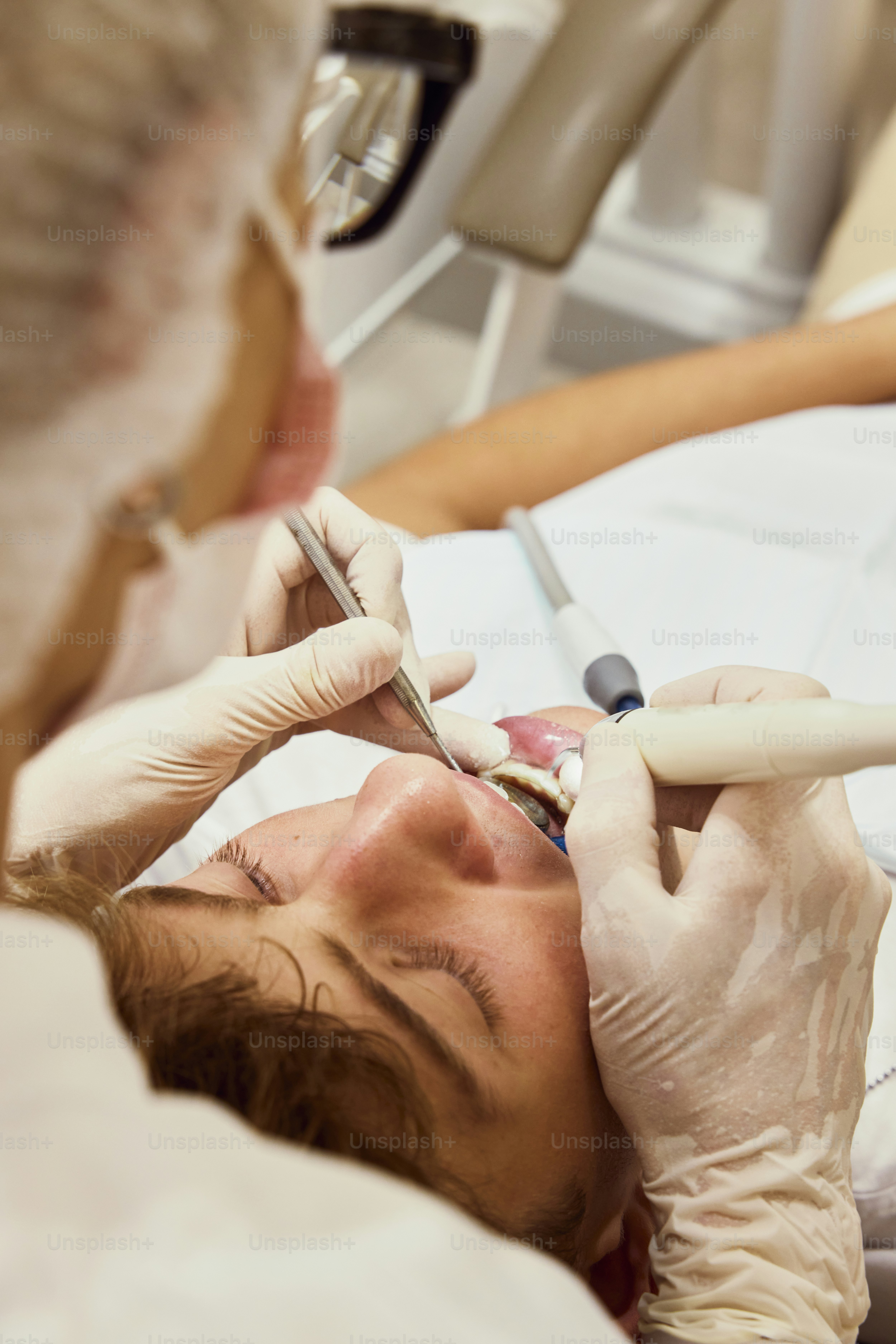 a woman getting her teeth checked by a dentist