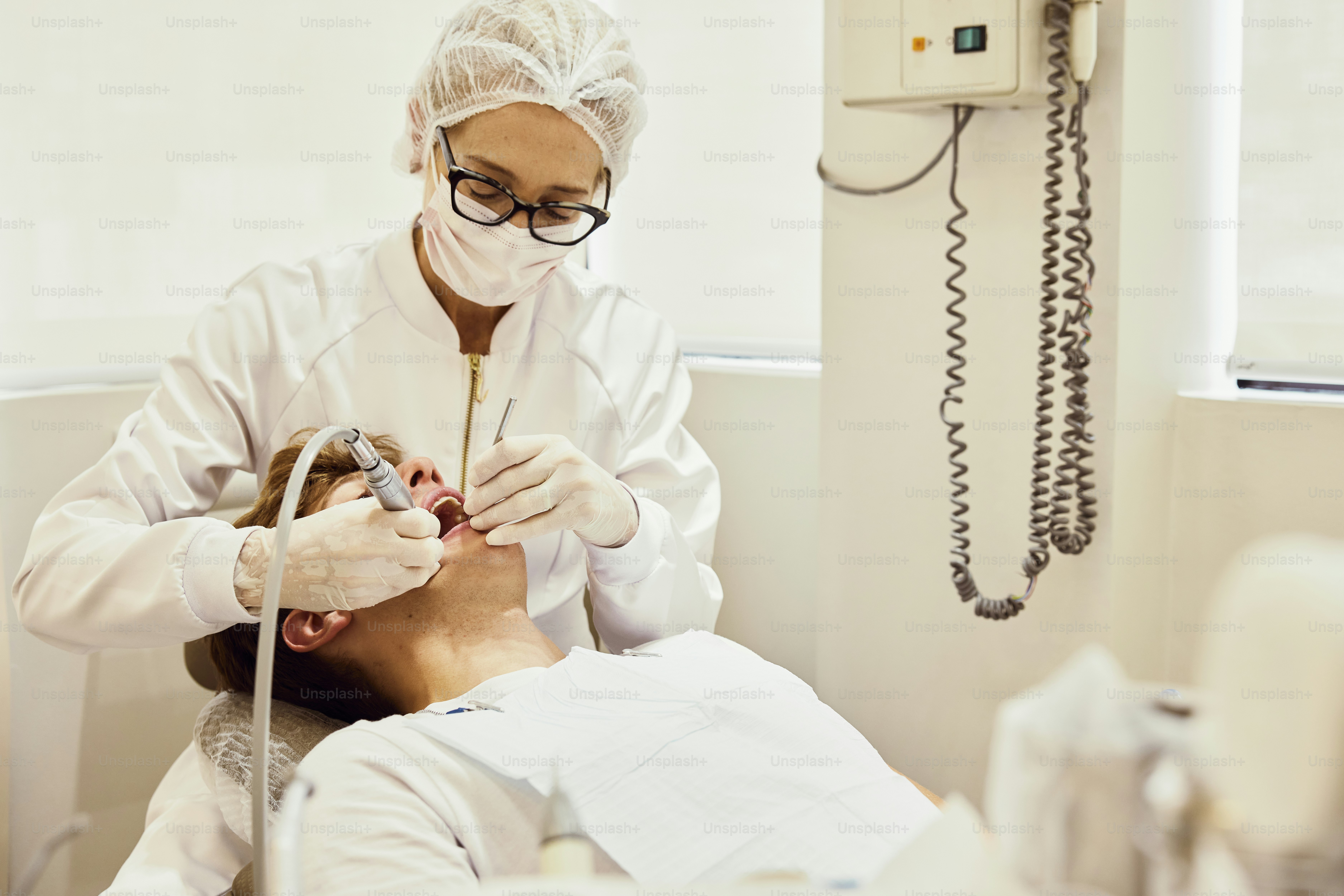 Un hombre que se hace revisar los dientes por un dentista