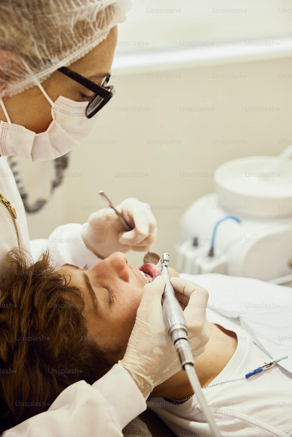 a woman getting her teeth checked by a dentist