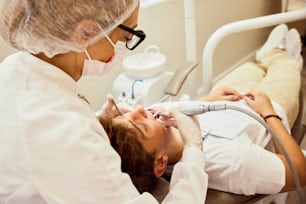 歯科医は手術室で患者の歯を検査します