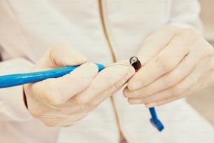 a person in white gloves holding a blue pen