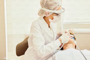 eine Person auf einem Zahnarztstuhl mit einer Maske
