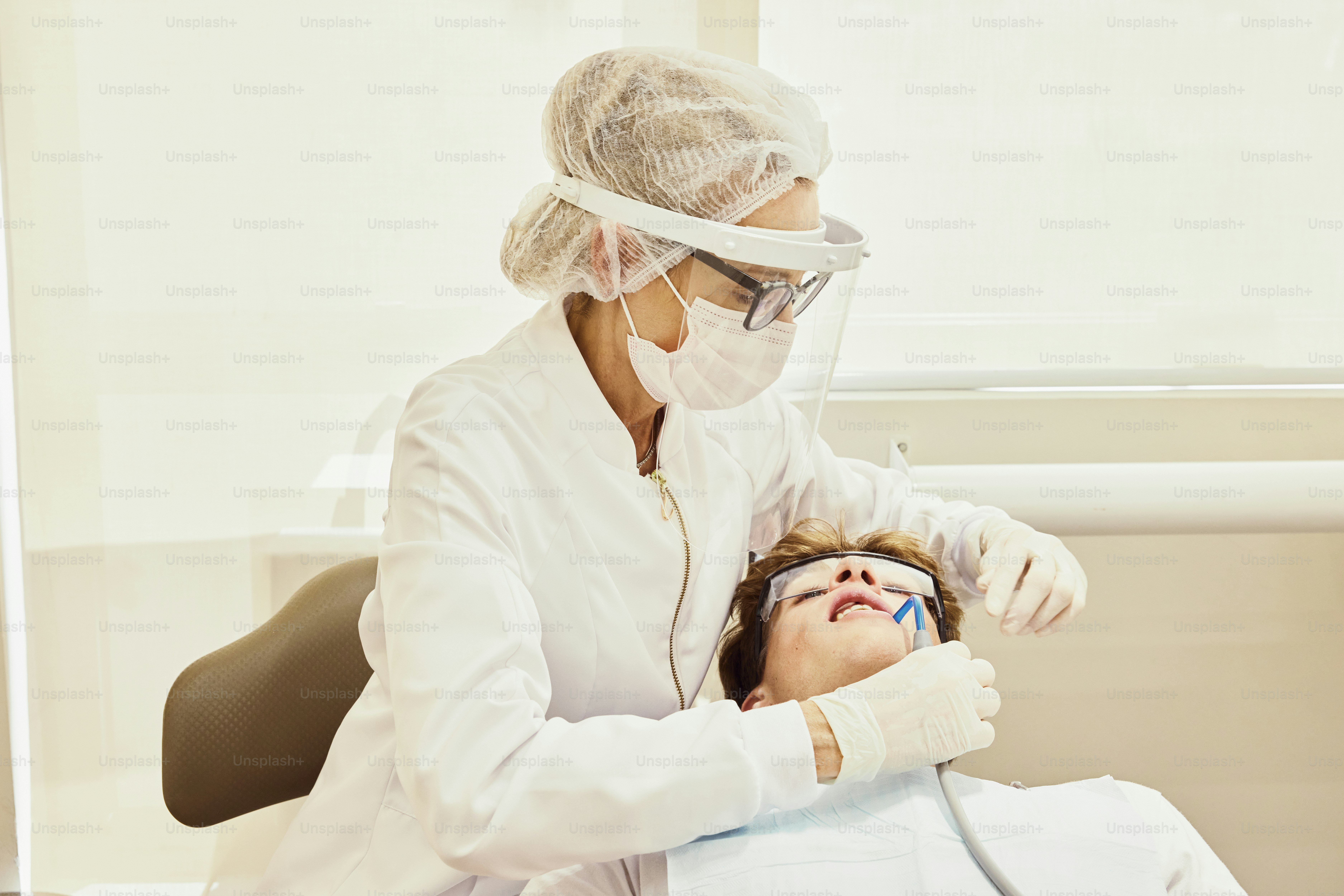 Eine Frau lässt ihre Zähne von einem Zahnarzt untersuchen