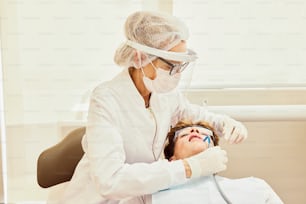 a woman getting her teeth checked by a dentist