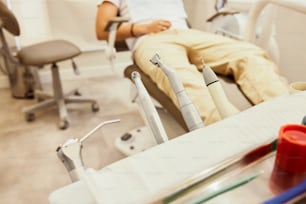 Un homme assis dans un fauteuil de dentiste avec des outils