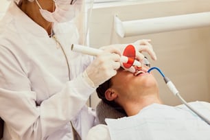 Un hombre que se hace revisar los dientes por un dentista