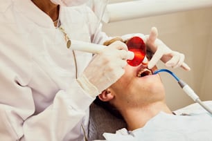 a man getting his teeth checked by a dentist