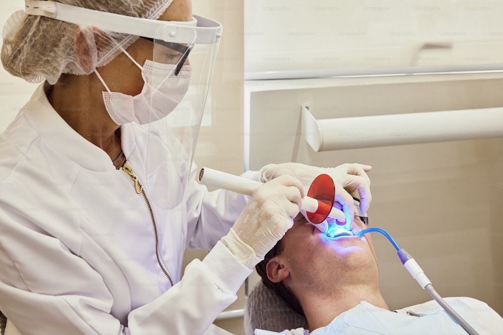 un homme se fait faire vérifier les dents par un dentiste