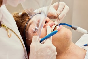 Un hombre que se hace revisar los dientes por un dentista