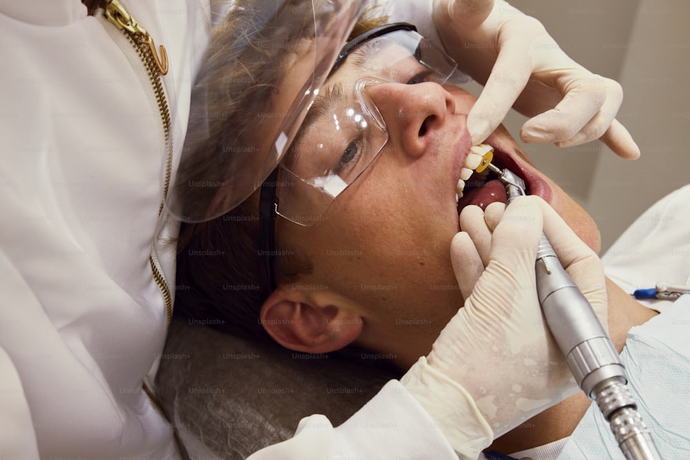 a man getting his teeth checked by a dentist