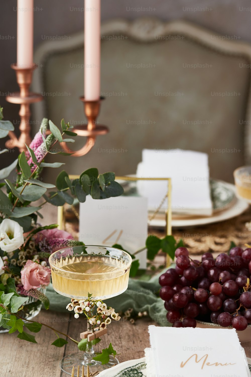 a table with a glass of wine and a place setting