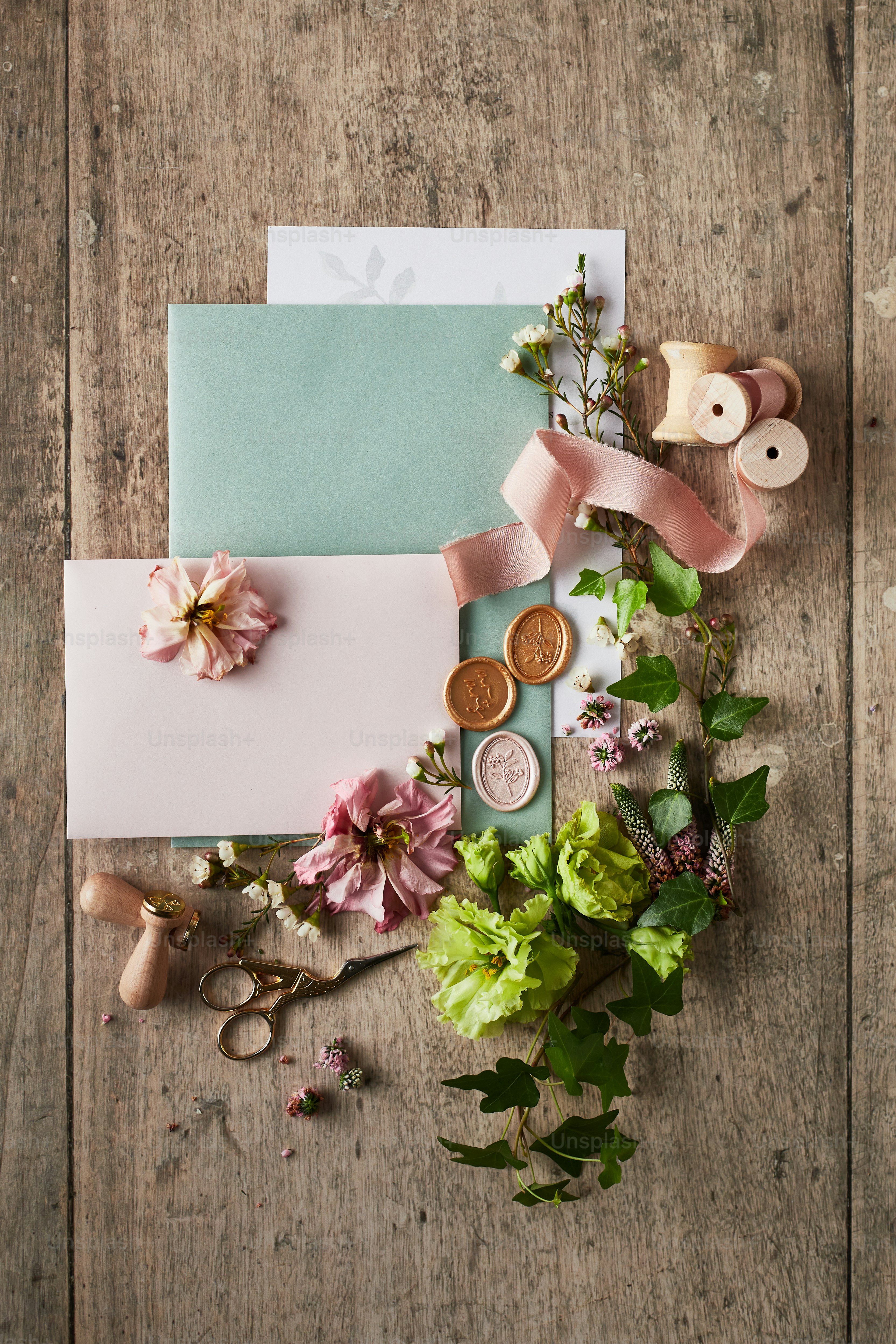 a wooden table topped with flowers and cards