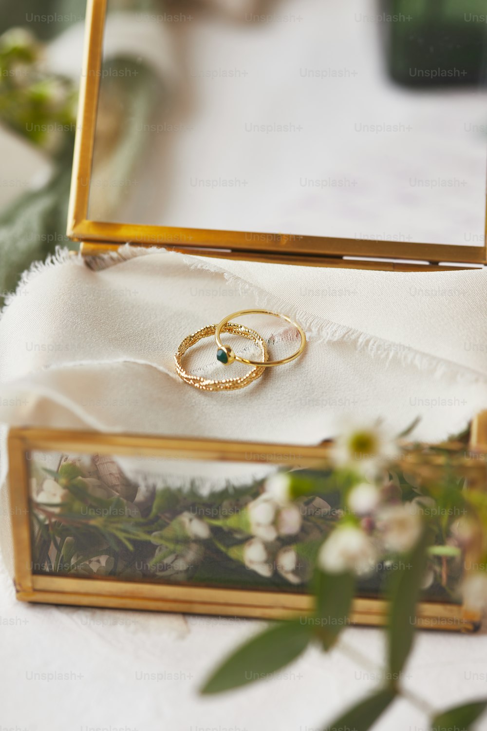 um par de anéis de casamento sentados em cima de uma mesa