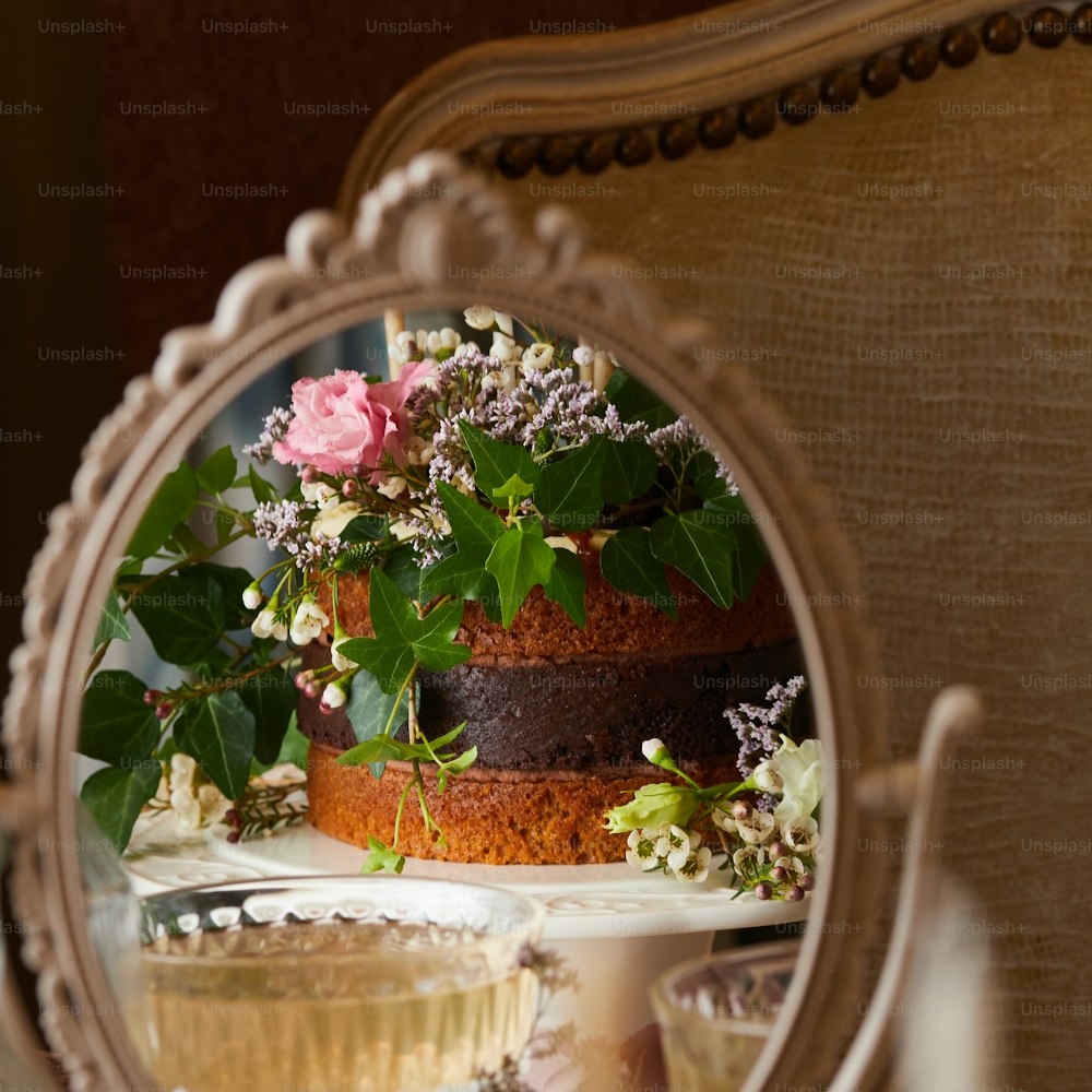 uno specchio che riflette una torta con fiori su di esso