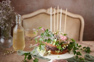 a cake sitting on top of a table covered in flowers