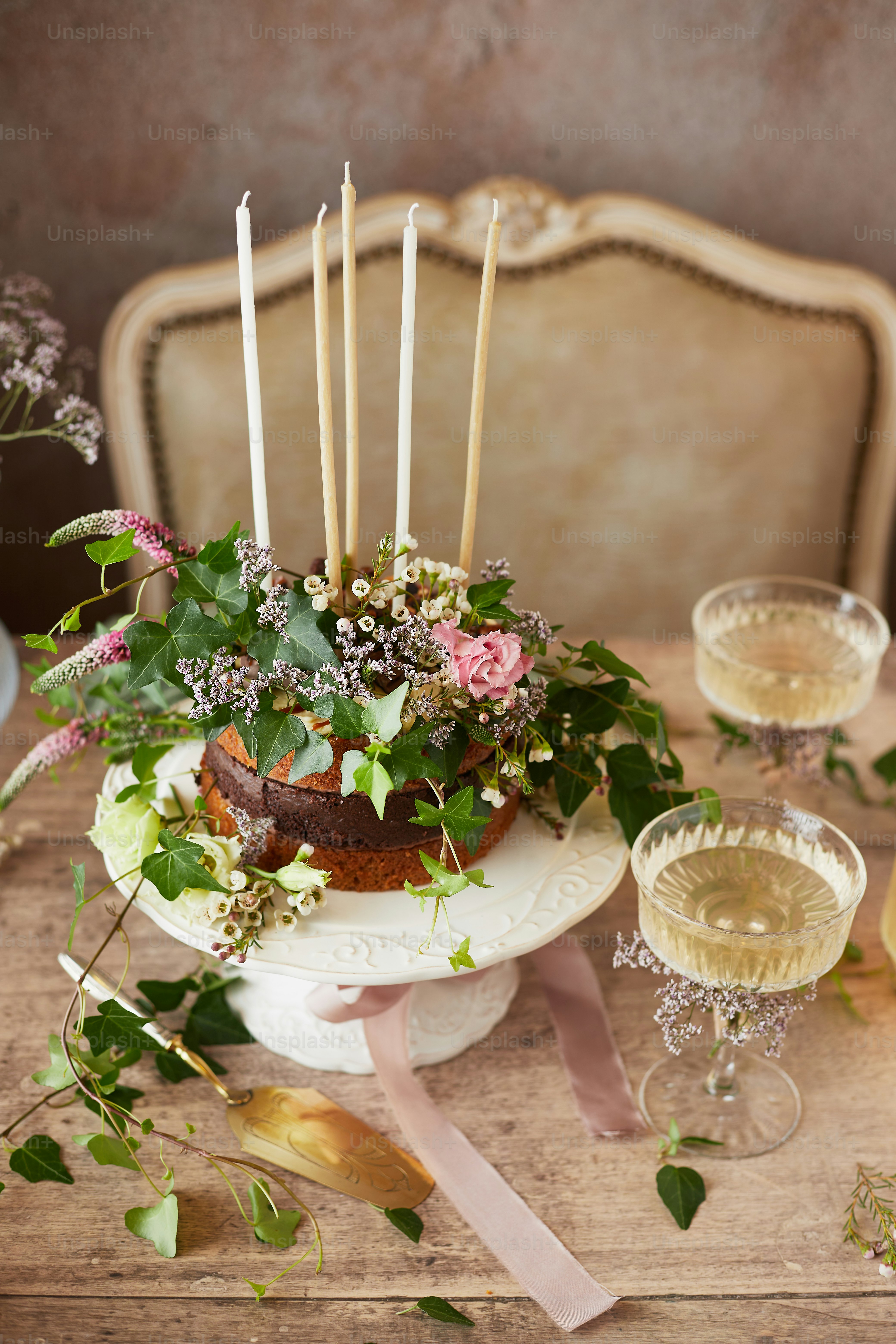 A table topped with a cake covered in flowers and candles photo