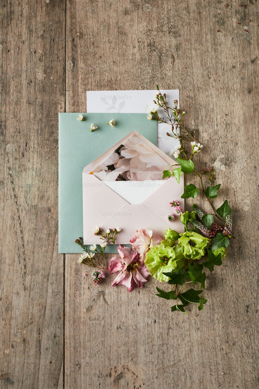 ein rosa Umschlag mit Blumen auf einem Holztisch