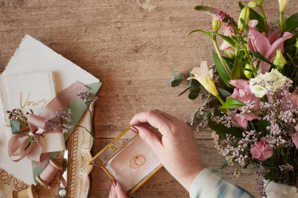 a person holding a card near a bouquet of flowers