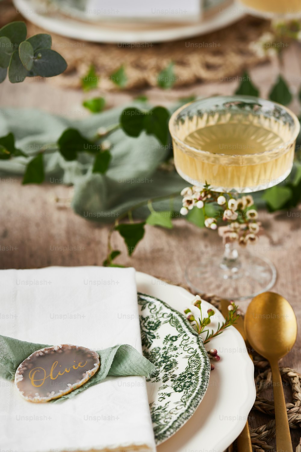 a table set with plates, silverware, and a glass of wine