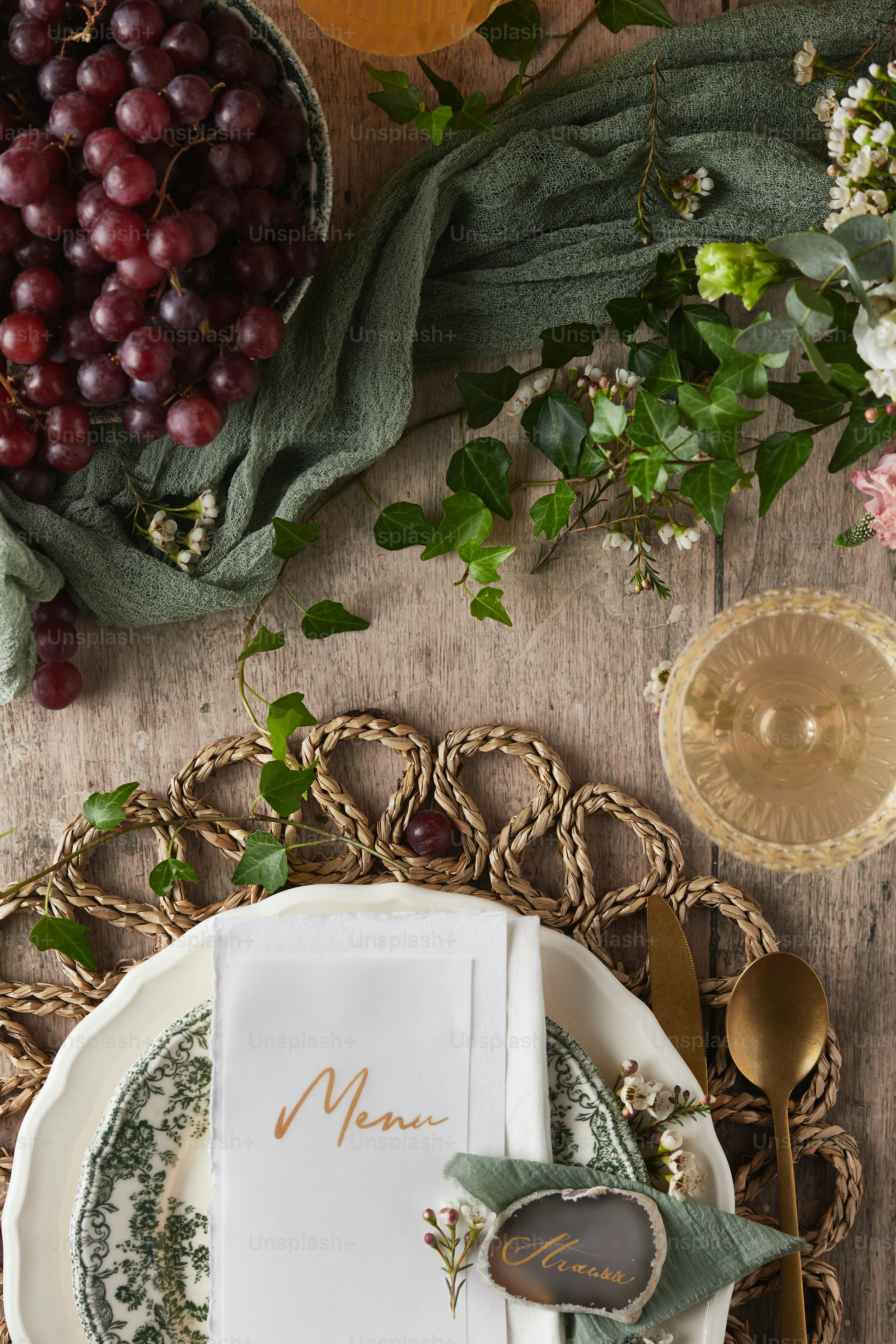 a place setting with grapes and a menu