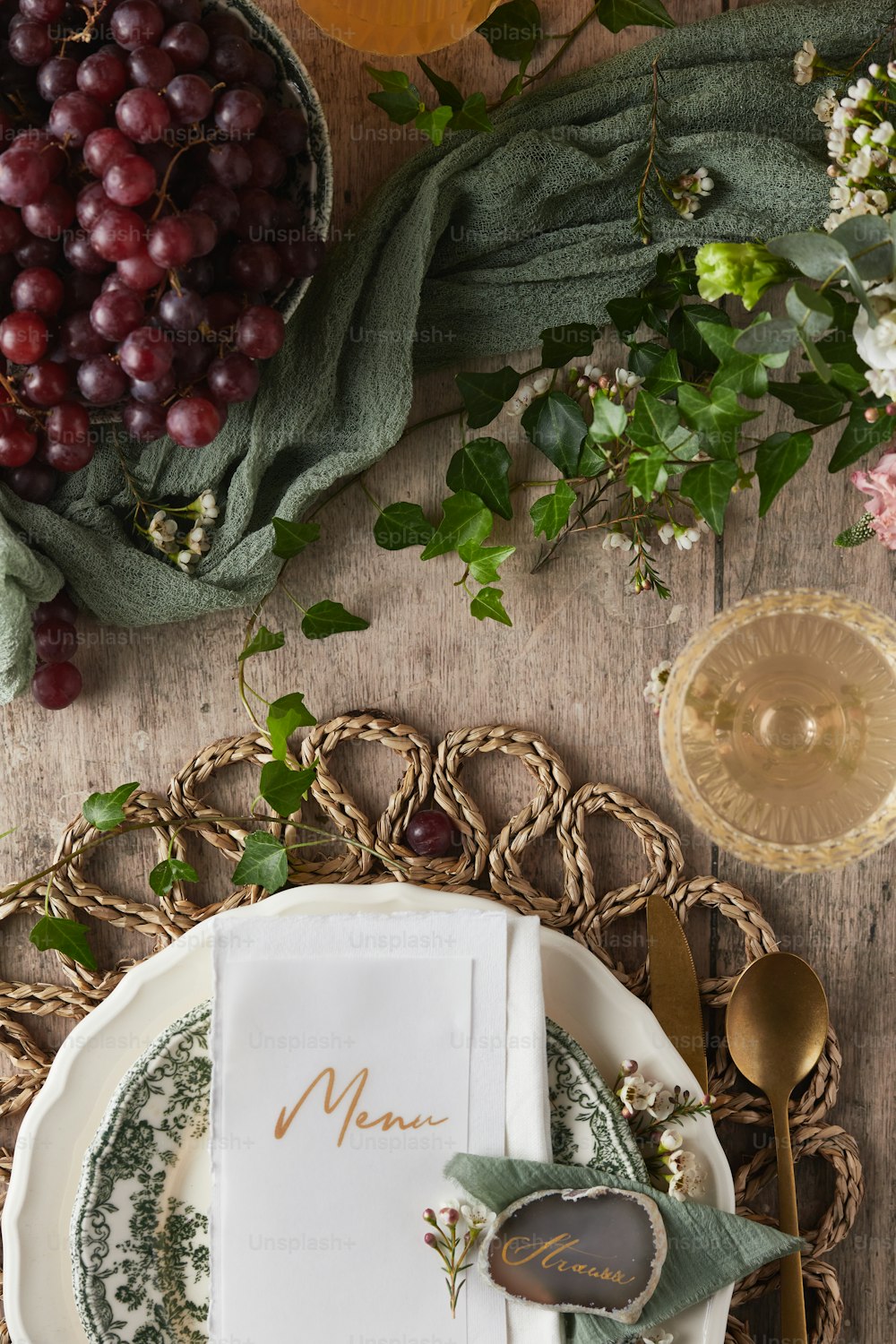 a place setting with grapes and a menu