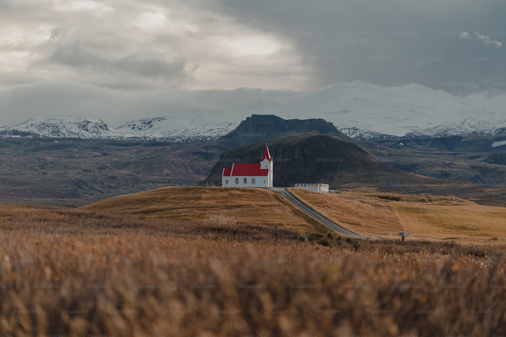 Eine kleine Kirche auf einem Hügel mit Bergen im Hintergrund