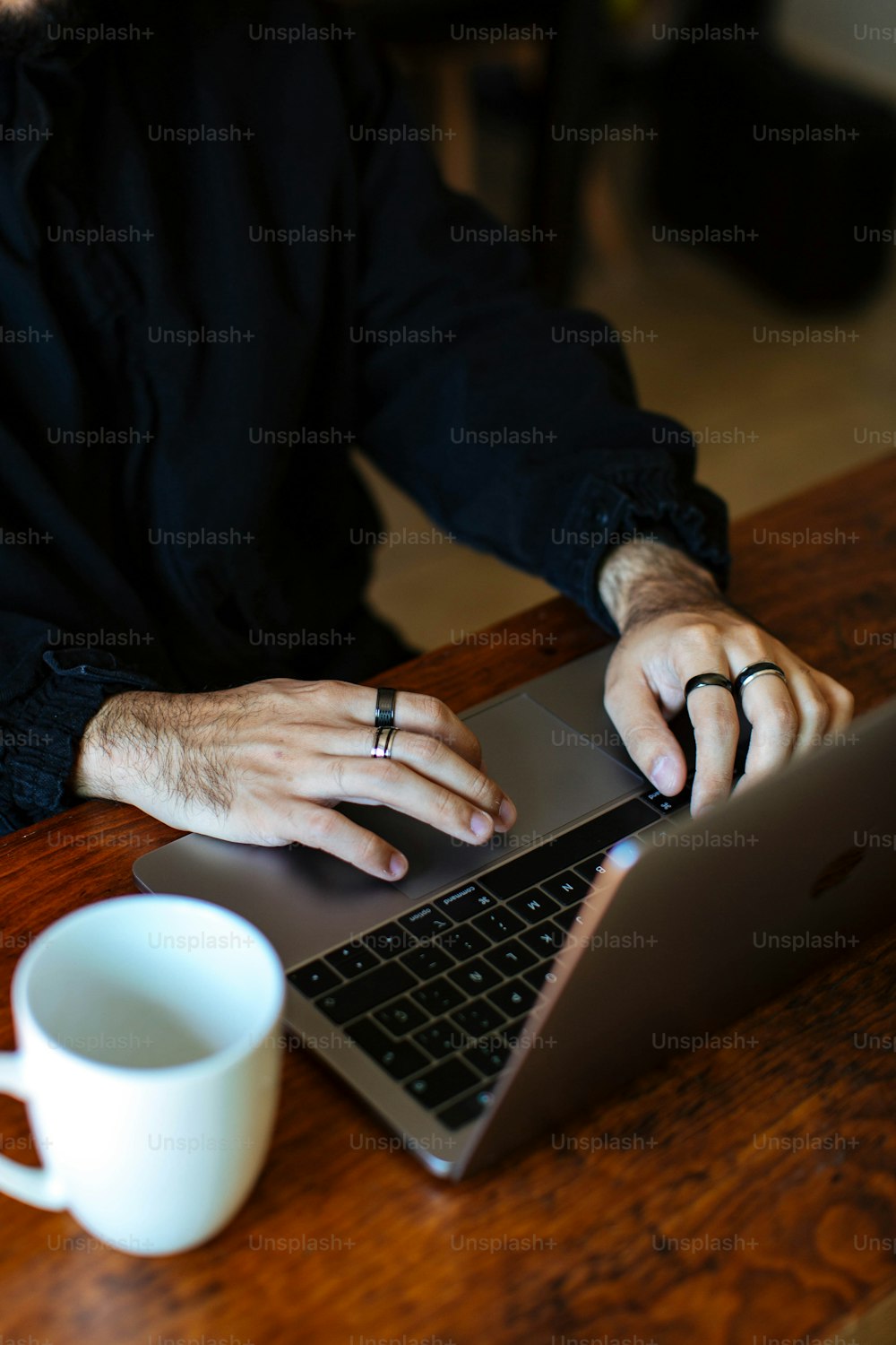 Ein Mann sitzt an einem Tisch mit einem Laptop