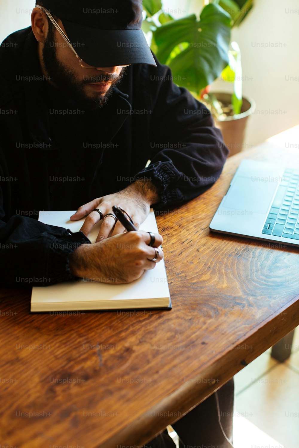 a man sitting at a table writing on a notebook