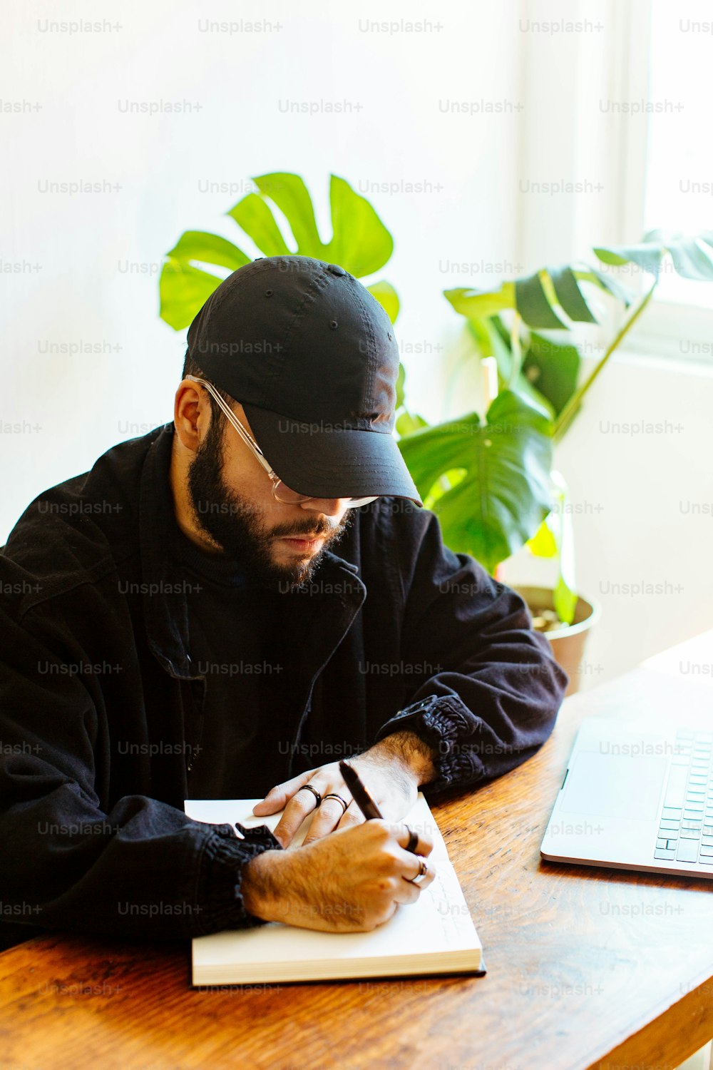 Un homme assis à une table écrivant sur un morceau de papier