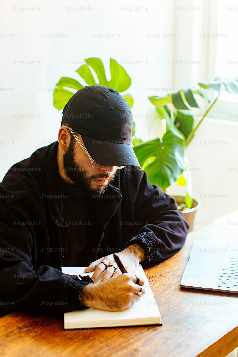 a man sitting at a table writing on a piece of paper