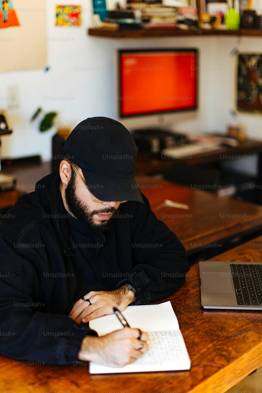 Un homme assis à un bureau écrivant sur un morceau de papier