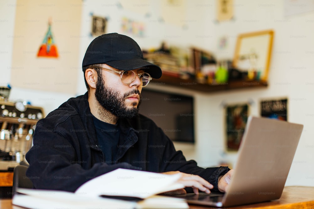 a man sitting at a table using a laptop computer