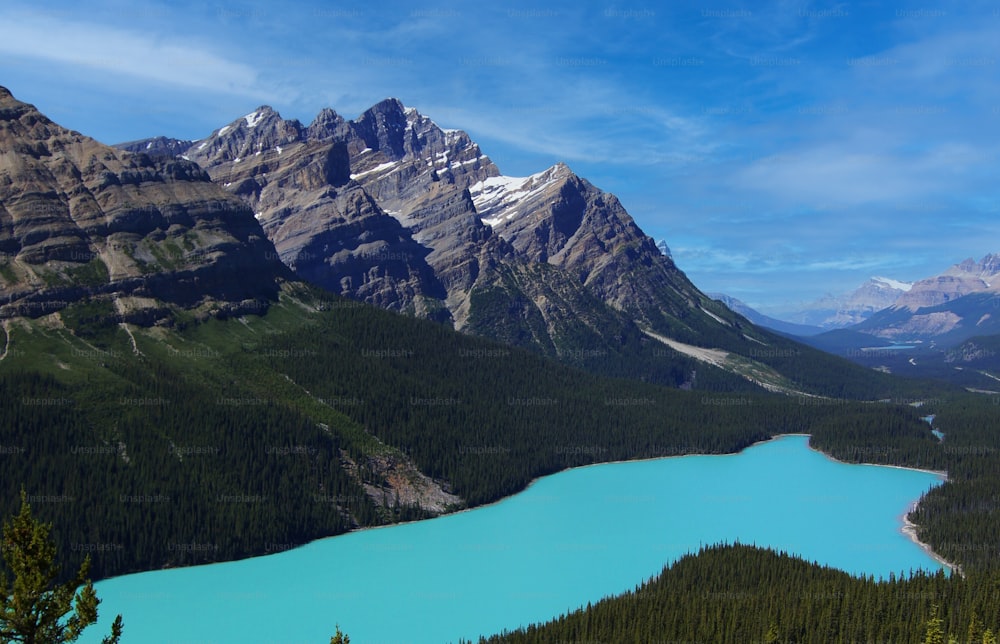 a blue lake surrounded by mountains under a blue sky