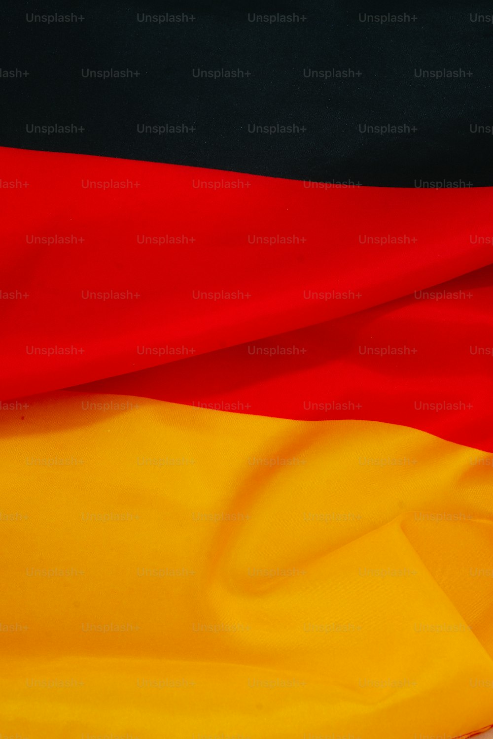 a close up of a red, yellow and black flag