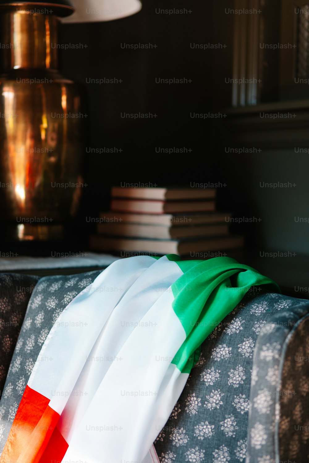 a green, white and red scarf sitting on top of a couch