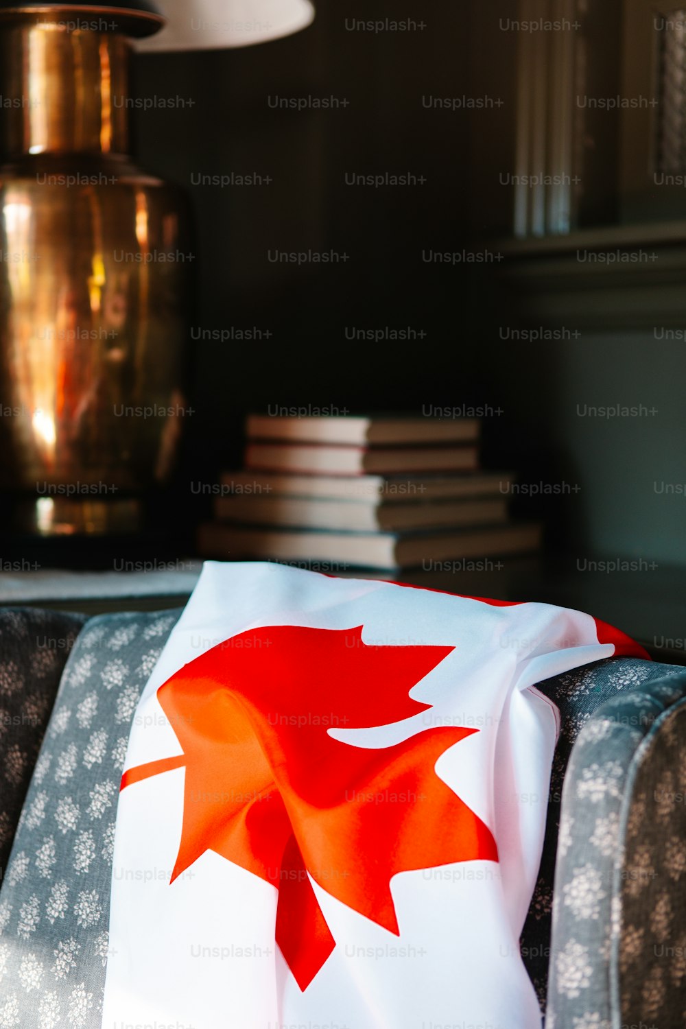 a red maple leaf on a white blanket on a couch